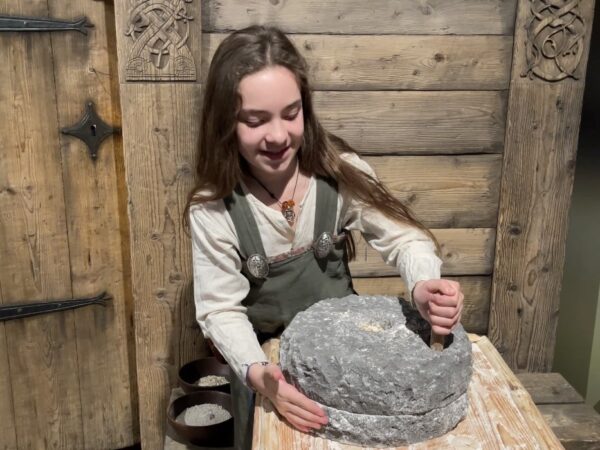 A child dressing in Viking Age clothing and holding a