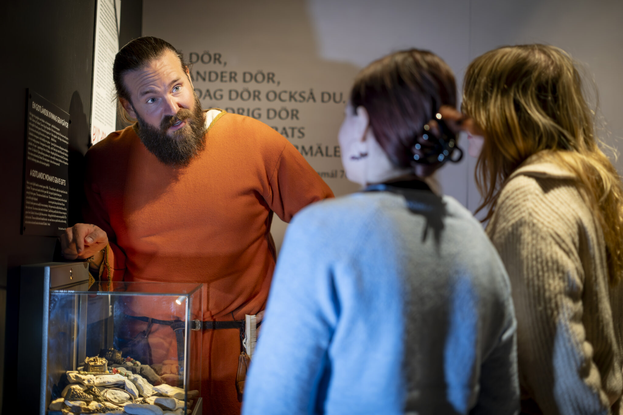 En guide visar en monter för museibesökare.