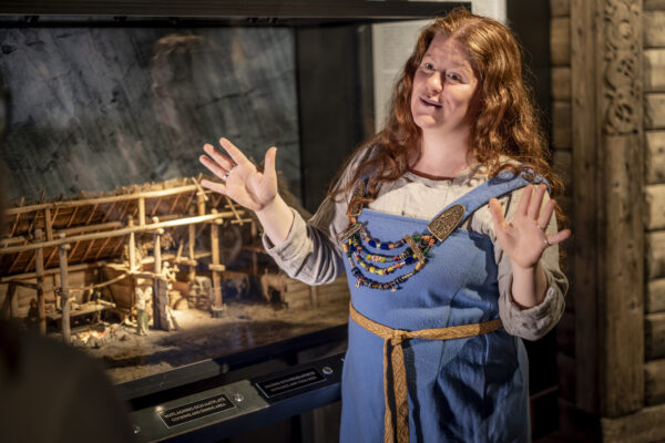 En guide i vikingakläder pratar i utställningen