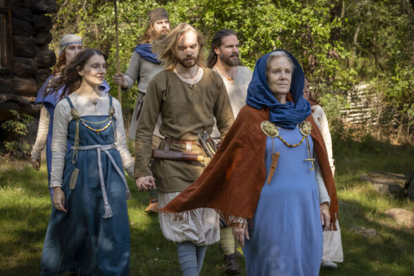 En grupp vikingar både män och kvinnor går tillsammans på sommaren.