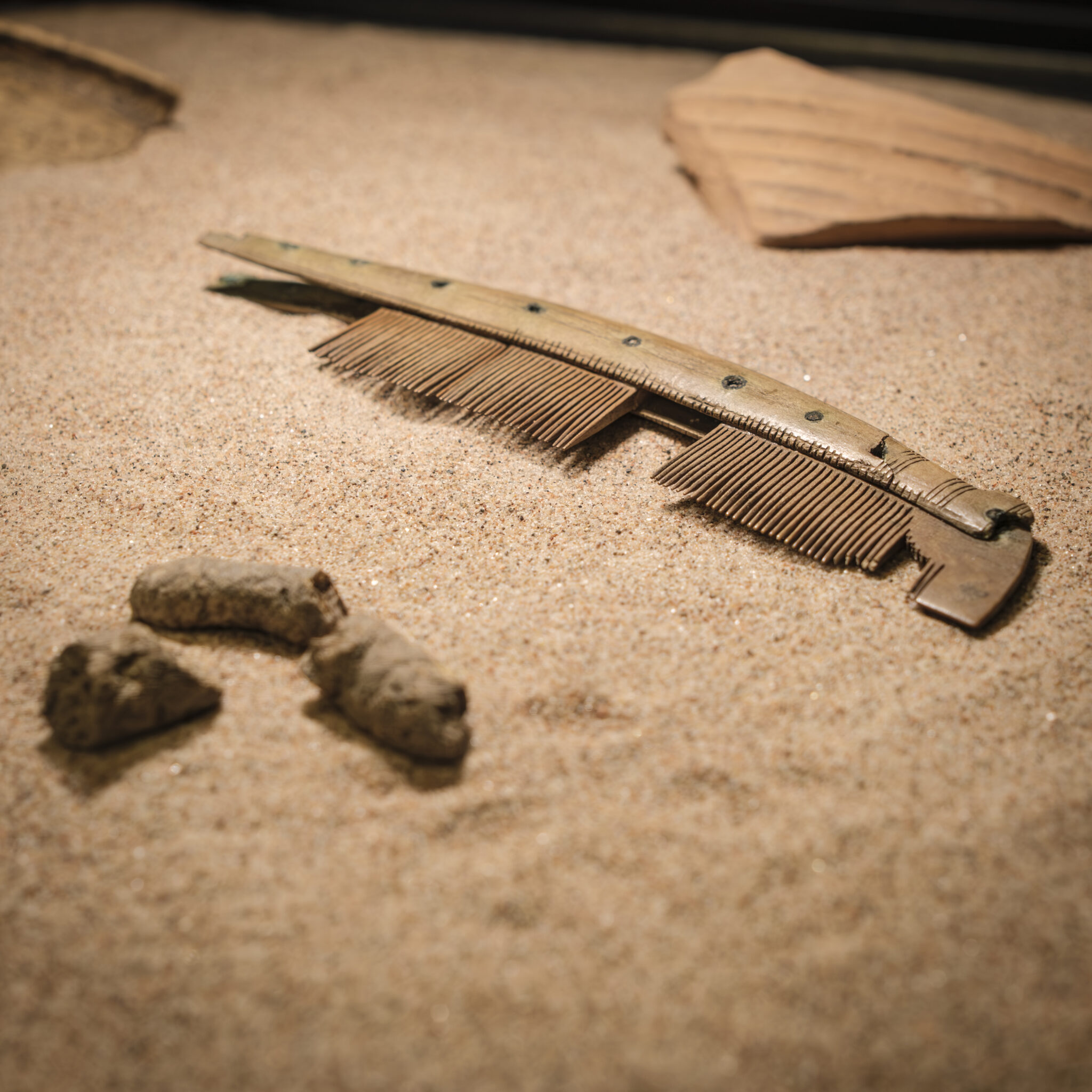 A Viking Age comb resting on sand.