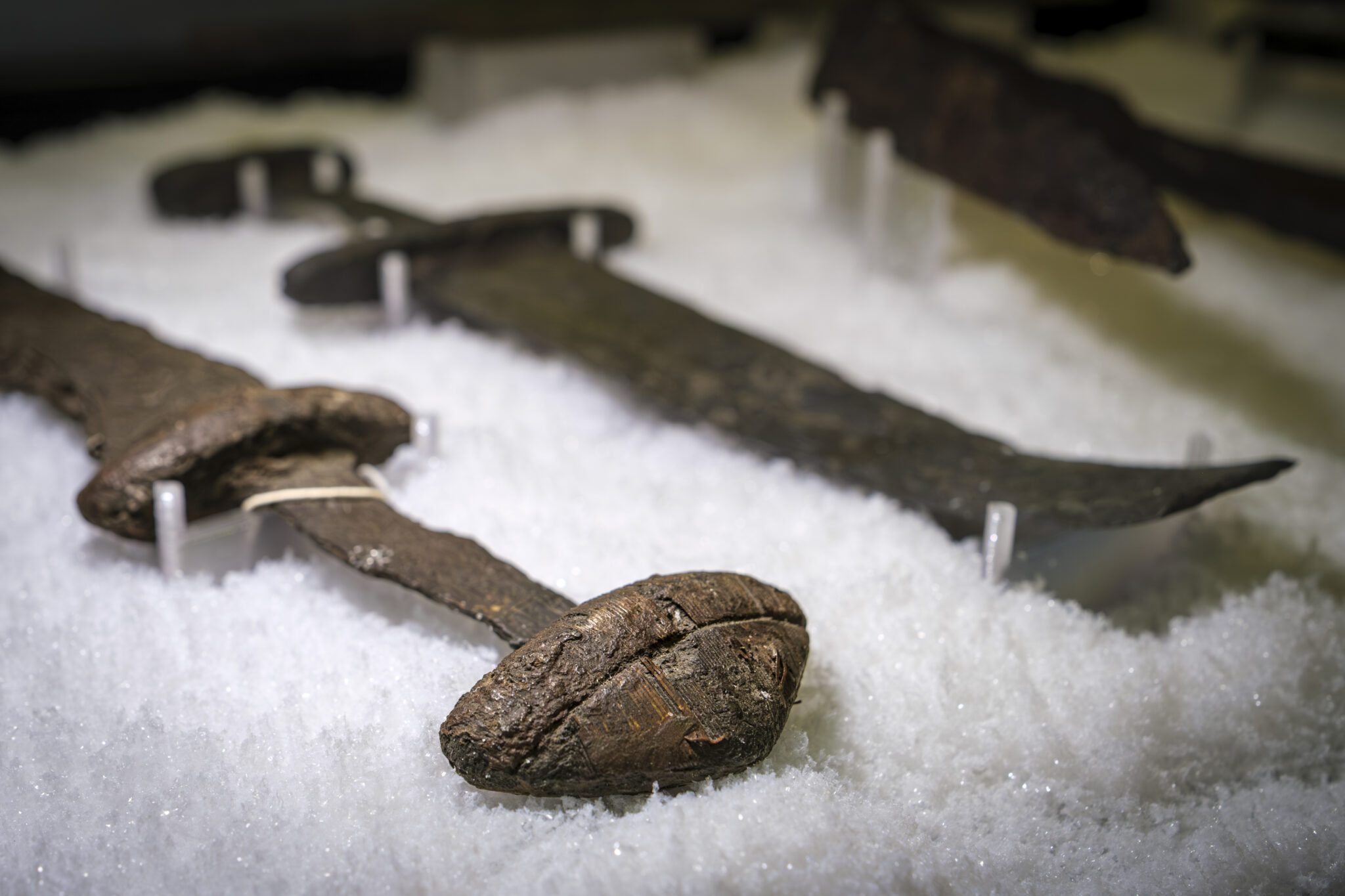 A Viking Age sword displayed in a showcase on top of artificial snow.